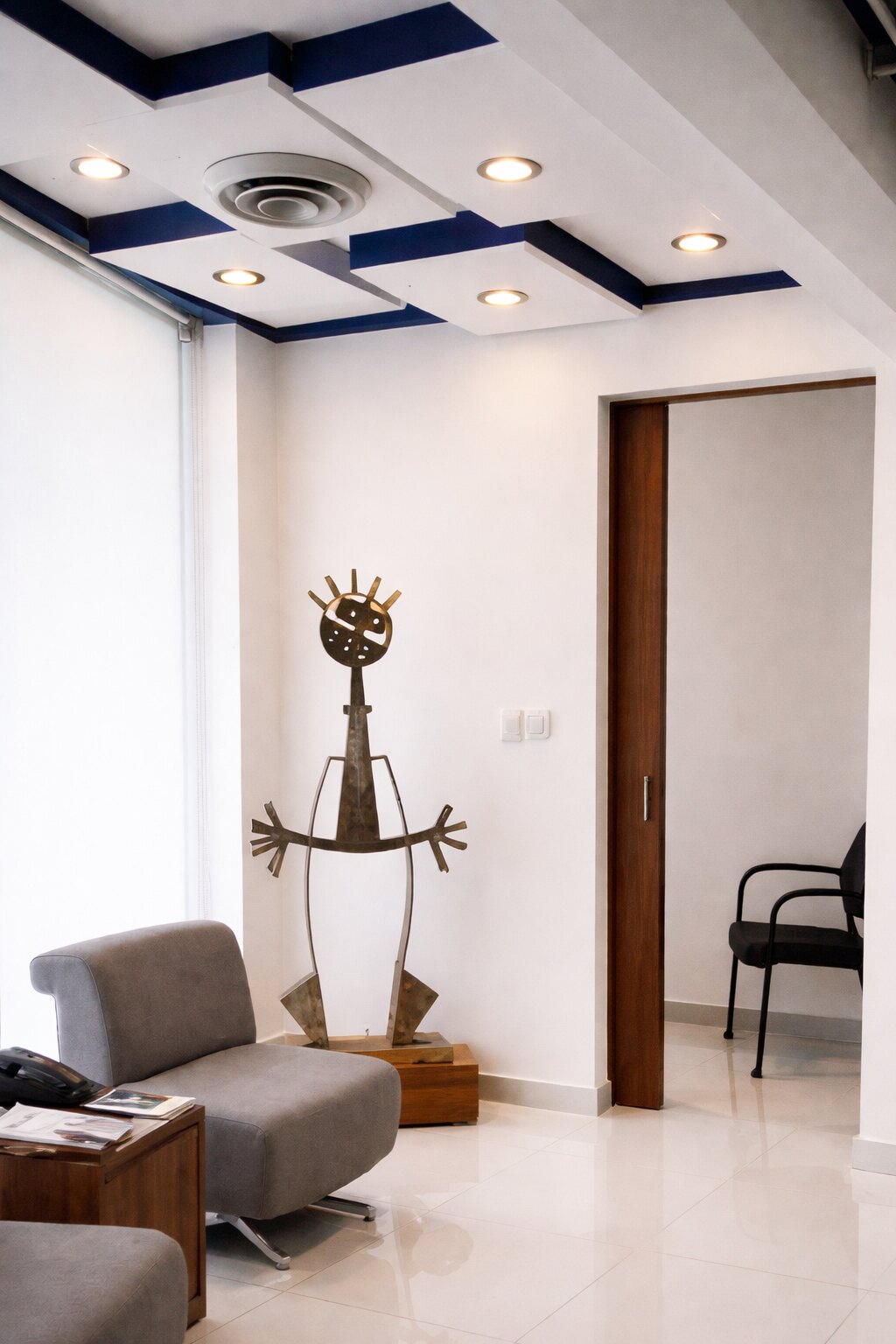 Detalle interior de Altipat: plafón, iluminación, puerta de madera y piso